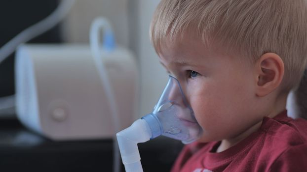 Funny boy breathing through an inhaler mask