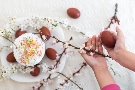 hands holding painted eggs. Easter cake.