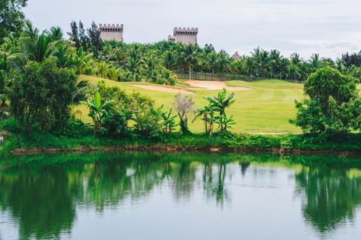 Scenic view beautiful golf course pond castle background view green lawn forest Reflection trees bush lush in water scenery valley lake country park.