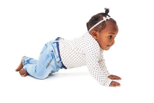 Just keep moving. Studio shot of a baby girl crawling against a white background
