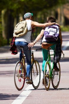 Cheers bro, good ride. Full length shot of two young guys cycling outdoors