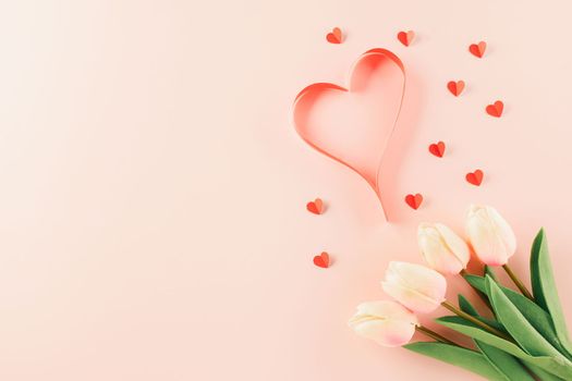 Happy Valentines Day background. Top view flat lay of red paper hearts shape and pink tulips flower on pink background with copy space