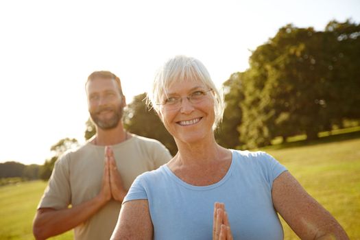 They met each other at a yoga class. a happy mature couple doing yoga together outdoors