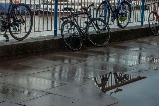 LONDON, UK - MAY 2, 2019 : Reflections in the water of the path banks of the River Thames after rain. Suitable for background images.