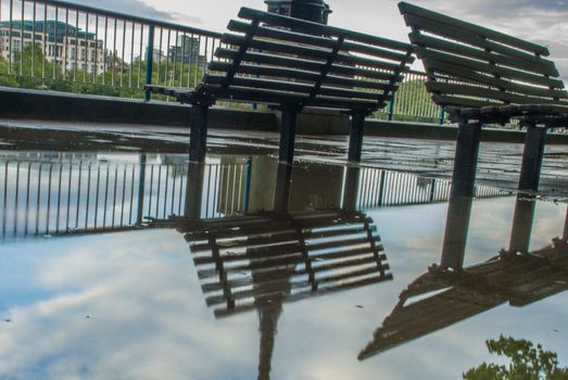 Reflections in the water of the path banks of the River Thames after rain. Suitable for background images.