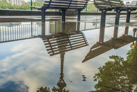 Reflections in the water of the path banks of the River Thames after rain. Suitable for background images.