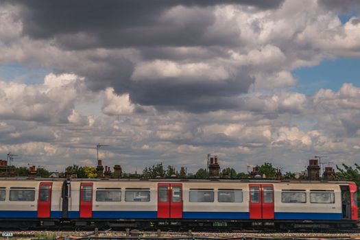 London 7 Jun 62 - Train running on the train track With a backdrop of beautiful sky and clouds.