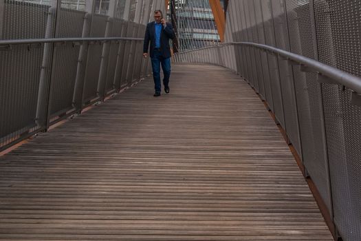 London 7 Jun 62 -  A business man walks along a bridge towards a modern looking building.