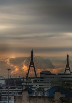 View of Bhumibol suspension bridge cross over Chao Phraya River in Bangkok city at beautiful sunset sky and clouds in Bangkok Thailand. Focus and blur.