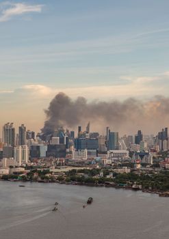 Bangkok, Thailand - Jun 23, 2020 : Aerial photograph of a group of black smoke rising from a fire on a tall building in Bangkok.