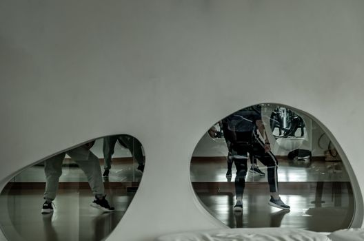 Bangkok, Thailand 11 Oct, 2019 : Young dancer in activewear training in front of large mirror in studio of modern dancing. looking through the glass window. copy space.