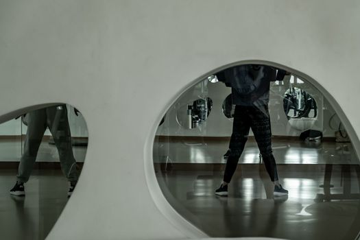 Bangkok, Thailand 11 Oct, 2019 : Young dancer in activewear training in front of large mirror in studio of modern dancing. looking through the glass window. copy space.