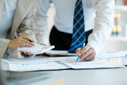 Close up of businesspeople, they are analyzing the strategic investment online working data. Businessteam is working with calculator for analyzed data report.