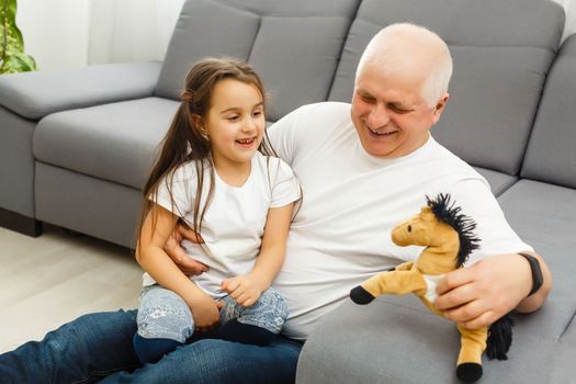 Elderly man holding his granddaughter