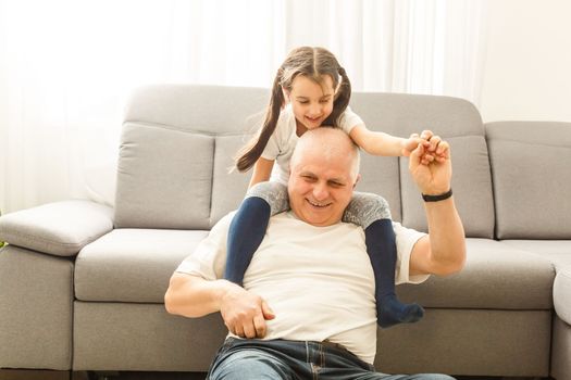 Little granddaughter hugging her grandfather