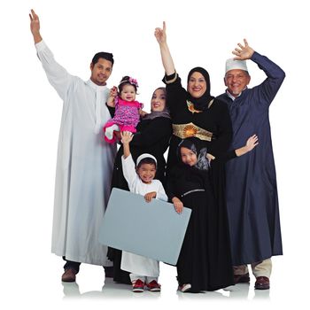 Celebrating culture. Studio portrait of an overjoyed muslim family holding up a blank sign isolated on white
