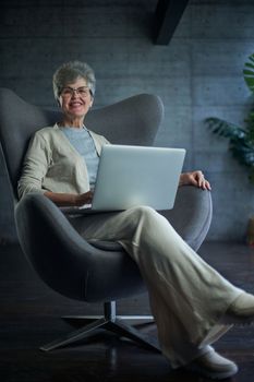 woman sitting in a chair in Art Nouveau style. Business, elegant businesswoman working on laptop . Interior, furniture.