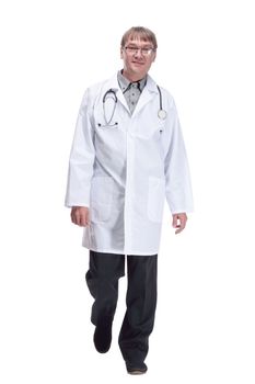 in full growth. friendly doctor with a stethoscope striding forward .isolated on a white background.