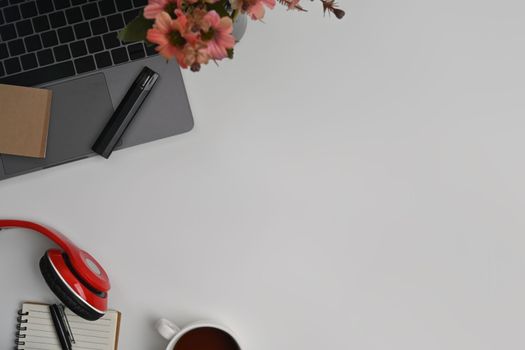 Laptop computer, headphone, notepad and coffee cup on white office desk. Top view with copy space.