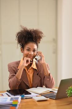 Portrait of confident female financial advisor having pleasant mobile phone conversation with client.