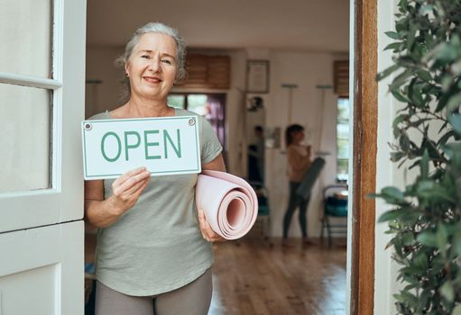 Woman, portrait and advertising open sign, yoga studio and fitness club, healthy lifestyle and senior wellness. Happy old woman at door of exercise, workout and training center with marketing signage.