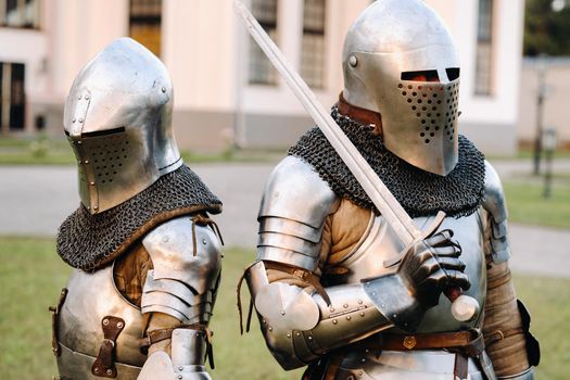 Two knights in armor on the background of a medieval castle.A medieval concept.Metallic texture.