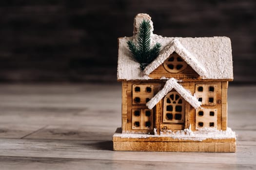 small snow-covered Christmas house on the floor of the house.Winter house decorative.