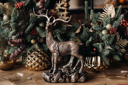 Christmas table decoration, Banquet table with glasses before serving food, Close-up of Christmas dinner table with seasonal decorations, crystal glasses and decorative deer.