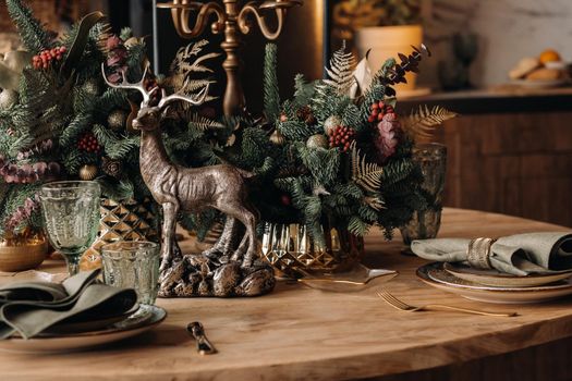 Christmas table decoration, Banquet table with glasses before serving food, Close-up of Christmas dinner table with seasonal decorations, crystal glasses and decorative deer.