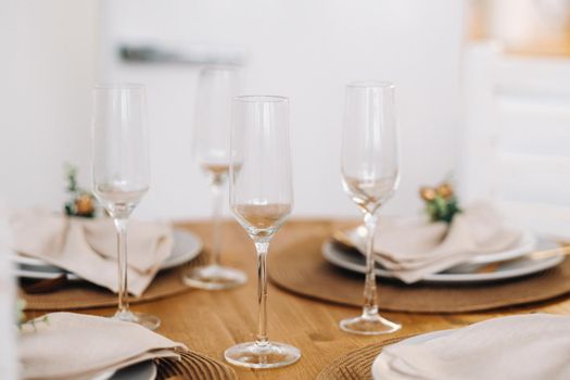 champagne glasses on the decorated Christmas table, crystal glasses at the table.