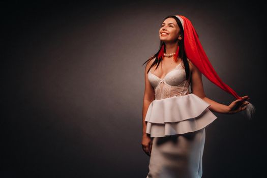 woman in Christmas hat and white dress on black background Christmas, holiday.