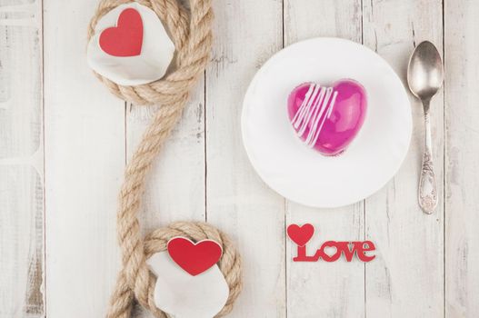 word love with red cake in the shape of a heart is on the white wood table. Romantic date. breakfast. Birthday. Wedding. Holiday. Top view