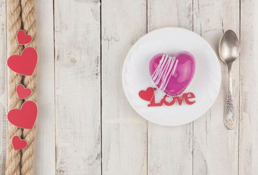 word love with red cake in the shape of a heart is on the white wood table. Romantic date. breakfast. Birthday. Wedding. Holiday. Top view