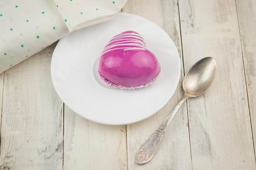 Red cake in the shape of a heart is on the table. Romantic date