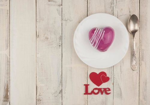 word love with red cake in the shape of a heart is on the white wood table. Romantic date. breakfast. Birthday. Wedding. Holiday. Top view