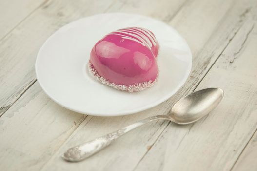 Red cake in the shape of a heart is on the table. Romantic date