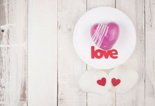 word love and white petals rose with red cake in the shape of a heart is on the table. Romantic date. 