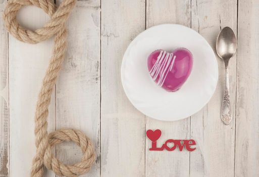 word love with red cake in the shape of a heart is on the white wood table. Romantic date. breakfast. Birthday. Wedding. Holiday. Top view