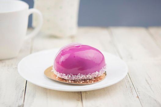 Red cake in the shape of a heart is on the table. Romantic date