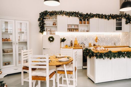 Christmas table decoration in the kitchen, Banquet table with glasses before serving food, close-up of the Christmas dinner table with seasonal decorations, crystal glasses and decorative deer.