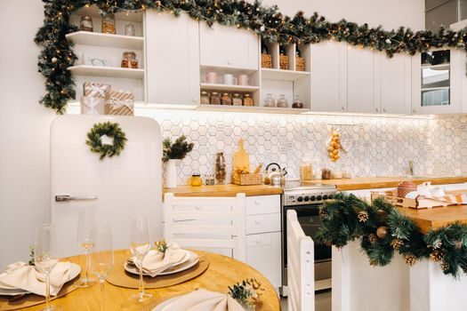 Christmas table decoration in the kitchen, Banquet table with glasses before serving food, close-up of the Christmas dinner table with seasonal decorations, crystal glasses and decorative deer.