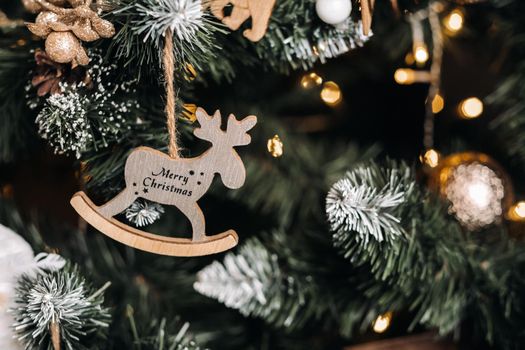 Christmas tree close-up with a hanging deer and the inscription merry Christmas.