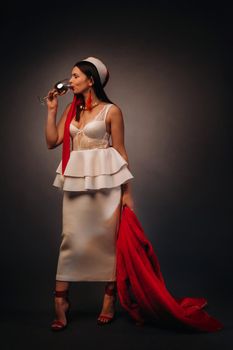 a woman in a Christmas hat and white dress, holding a glass and a red fur coat in her hands, on a black background, Christmas, holiday,