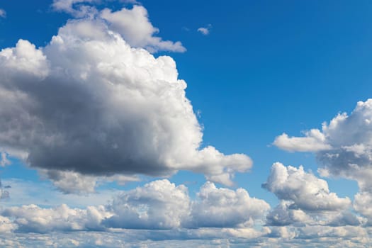 White cumulus fluffy clouds In a blue sky. Background from clouds.