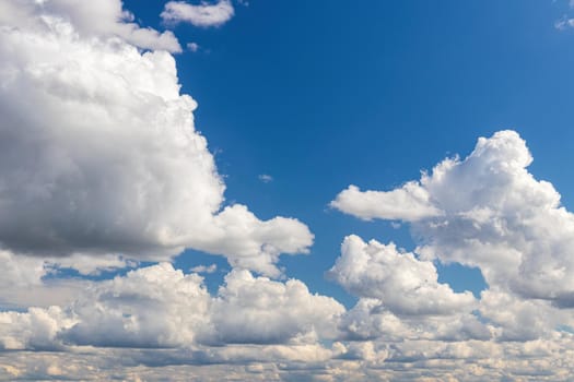 White cumulus fluffy clouds In a blue sky. Background from clouds.