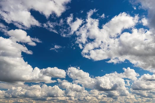 White cumulus fluffy clouds In a blue sky. Background from clouds.