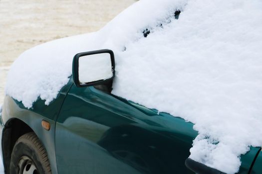 Car in the snow. Bad weather in severe weather. Inoperative transport in the courtyard of the house