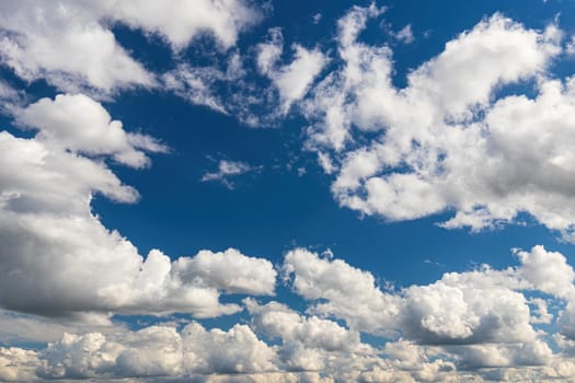 White cumulus fluffy clouds In a blue sky. Background from clouds.