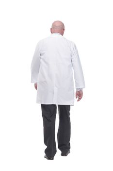in full growth. confident mature doctor in a white coat striding forward .isolated on a white background.