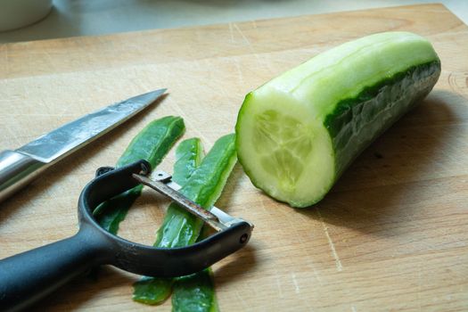 A close-up of kitchen accessories for peeling green cucumber